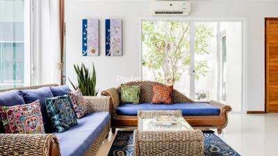 Bright living room with wicker furniture and colorful cushions