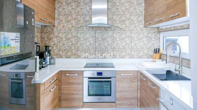 Modern kitchen with wooden cabinets and stainless steel appliances