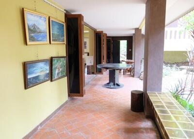 Bright hallway with art on the walls and a round table