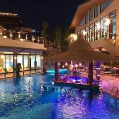 Luxurious outdoor pool area at night with bar seating