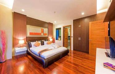 Modern bedroom with double bed, wooden flooring, and contemporary decor