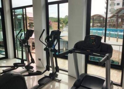 Home gym with cardio equipment and large windows overlooking an outdoor area