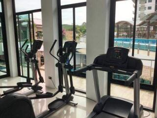 Home gym with cardio equipment and large windows overlooking an outdoor area