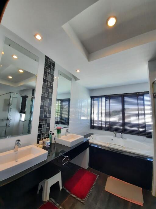 Modern bathroom with double sinks, large bathtub, and big windows