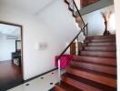 Staircase and hallway with view into adjacent room