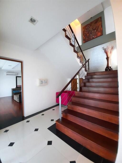 Staircase and hallway with view into adjacent room