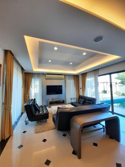 Modern living room with leather sofas and a view of the pool