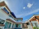 Modern multi-story house with large windows and outdoor pool against a clear blue sky