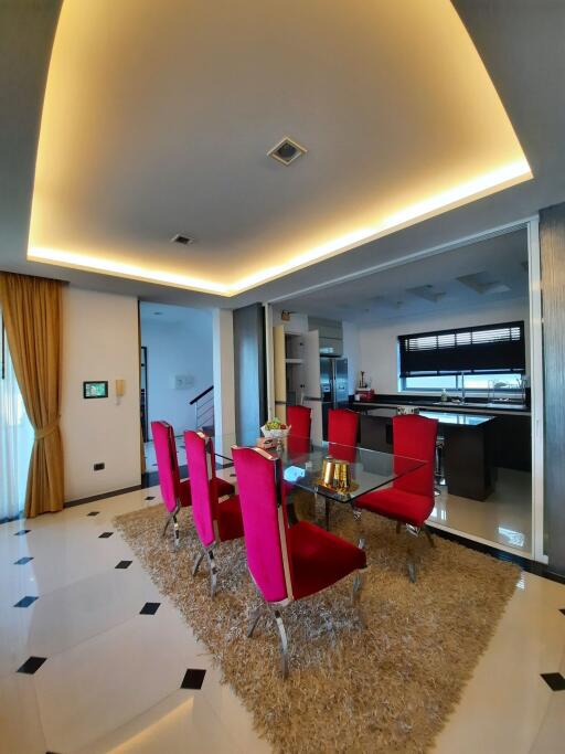 Modern dining area with red chairs and glass table