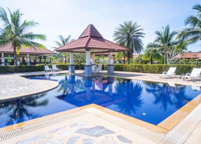 Luxurious outdoor swimming pool with palm trees and lounge chairs