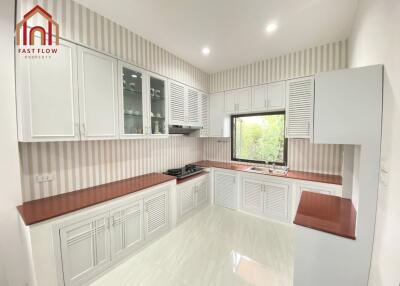 Modern kitchen with white cabinets and wooden countertops