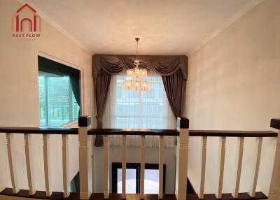 View of elegant hallway with chandelier and large window