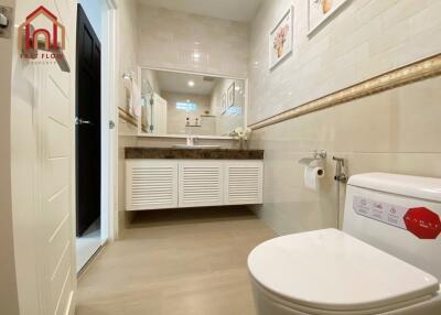 Modern bathroom with large vanity, mirror, and toilet