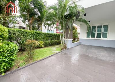 View of a building exterior with a garden and paved area