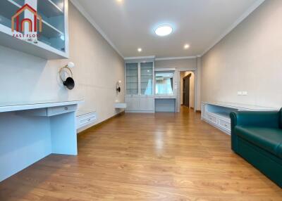 Spacious living room with wooden flooring and built-in shelves