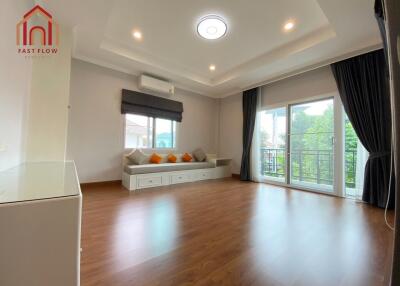 Spacious living room with wooden flooring and large windows