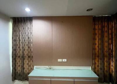 Bedroom with wall-mounted desk and brown curtains