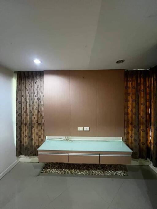 Bedroom with wall-mounted desk and brown curtains