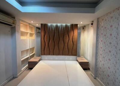 Modern bedroom with built-in shelves and ambient lighting