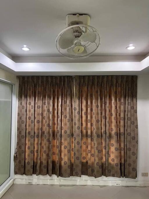 Living room with ceiling fan and patterned curtains