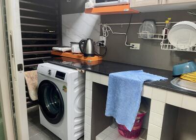 Laundry area with washing machine, counter space, and storage