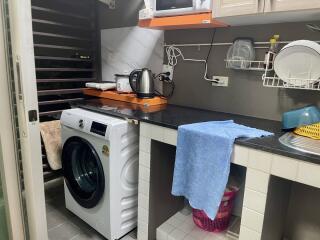 Laundry area with washing machine, counter space, and storage