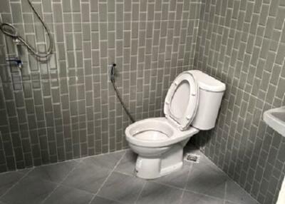 Bathroom with toilet and tiled walls