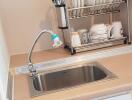 a compact kitchen with a sink and dish rack