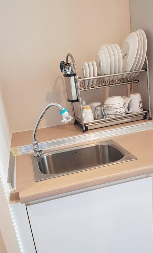 a compact kitchen with a sink and dish rack