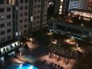 Night view of building courtyard with illuminated swimming pool