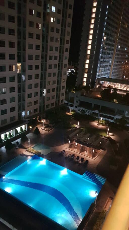 Night view of building courtyard with illuminated swimming pool