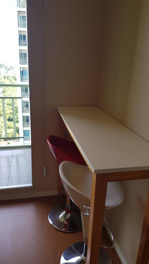 Small dining area with high table and chairs next to a balcony