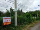 Vacant land with prominent signage and utility poles