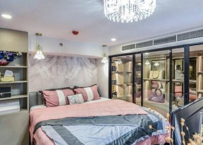 Modern bedroom with pink bedding and a chandelier