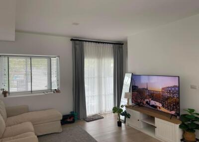 Bright and cozy living room with large window and television