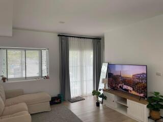 Bright and cozy living room with large window and television