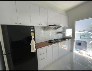 Modern kitchen with white cabinets and black refrigerator