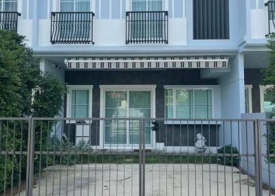 Modern two-story townhouse exterior with gated driveway and balcony