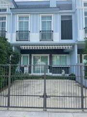 Modern two-story townhouse exterior with gated driveway and balcony