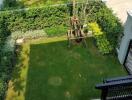 Aerial view of a well-maintained garden with a tree and surrounding hedges.