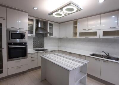 Modern kitchen with white cabinets, island, and built-in appliances