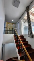 Indoor staircase with wooden steps and a modern railing