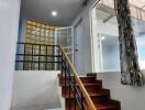 Indoor staircase with wooden steps and a modern railing