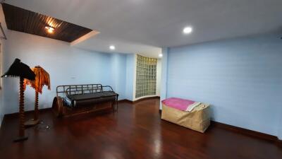 Simple bedroom with wooden flooring and furniture