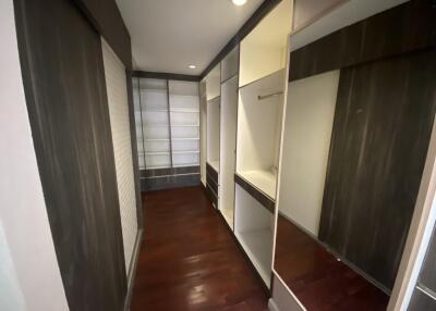 Spacious walk-in closet with wooden flooring and built-in shelves