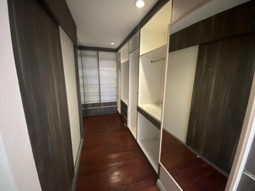 Spacious walk-in closet with wooden flooring and built-in shelves