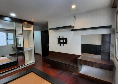 Spacious bedroom with built-in shelves and mirrored closet