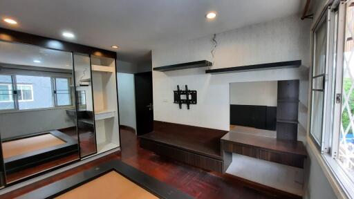 Spacious bedroom with built-in shelves and mirrored closet