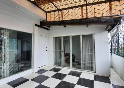 Covered patio with glass sliding door and checkered flooring