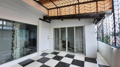 Covered patio with glass sliding door and checkered flooring